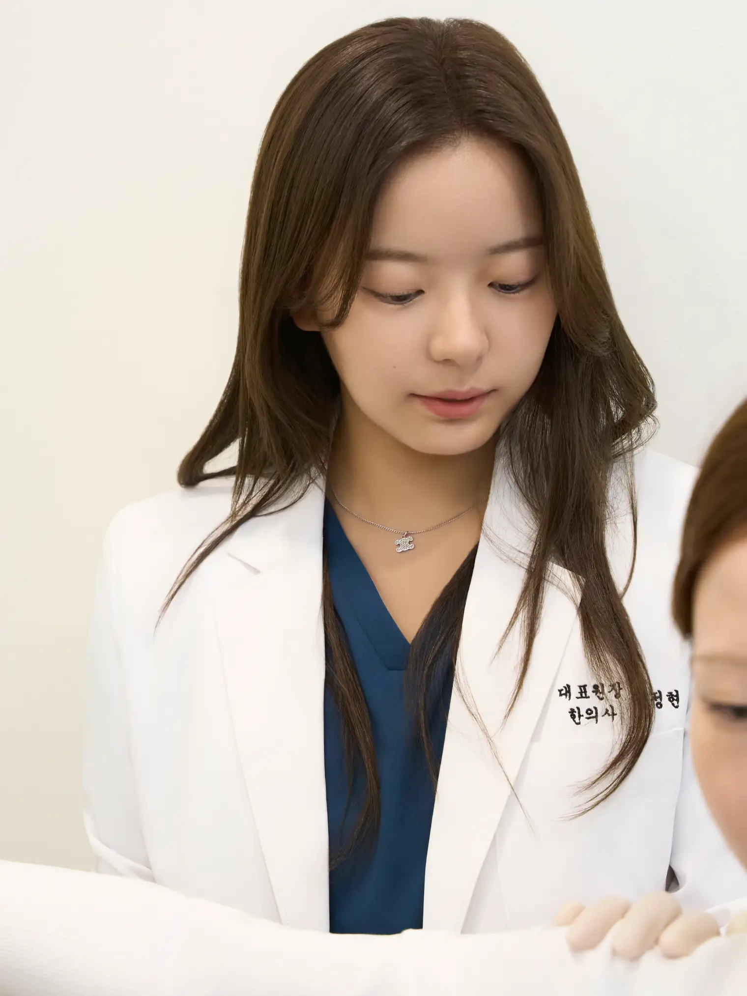 Dr. Jeonghyeon Kim leaning toward a patient to check their condition
