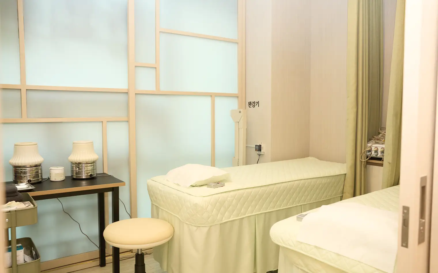 Treatment bed at NuA Korean Medicine Clinic separated by a traditional window-lattice partition