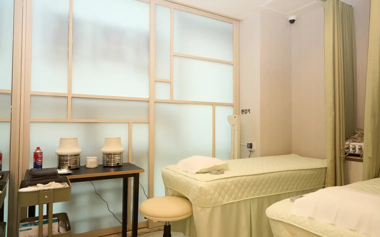 Treatment rooms divided by traditional lattice partitions, with a moxibustion device