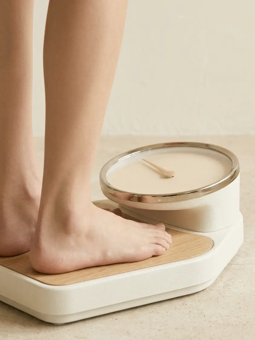 Bare feet standing on an analog scale