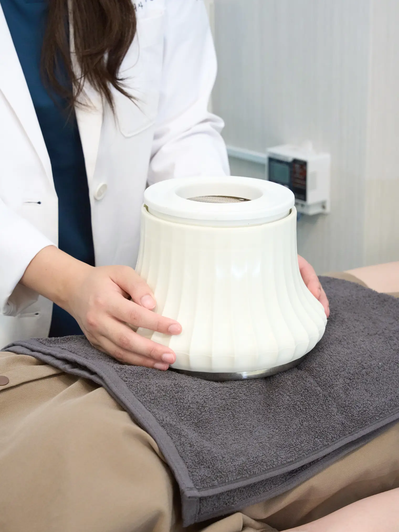 Preparing mugwort moxibustion by placing a moxa warmer on a patient's abdomen